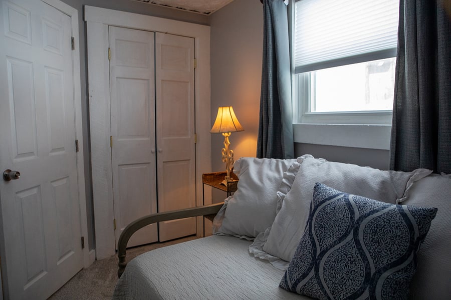 This is the small bedroom. It has a day bed, a night stand a closet and a window but is quite small.