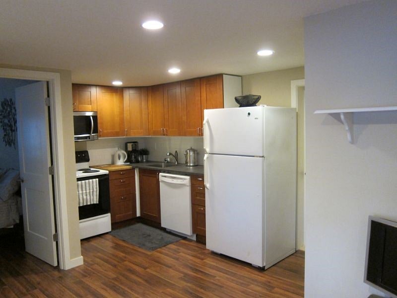 Kitchen, full size range, dishwasher, microwave, hood vent vented to outside, and fridge with ice maker