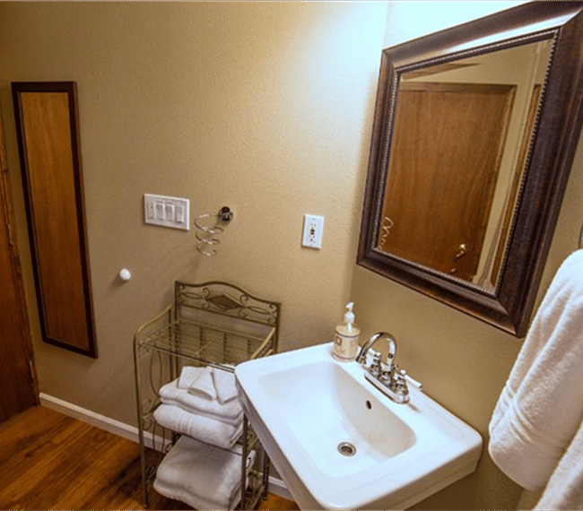 Zoom lens photo of bathroom, bathroom door closed. Long mirror behind door.