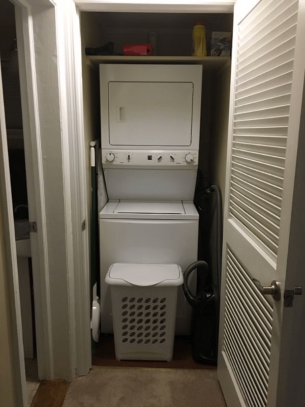 Laundry room with stacked washer/dryer & bathroom entrance on the left