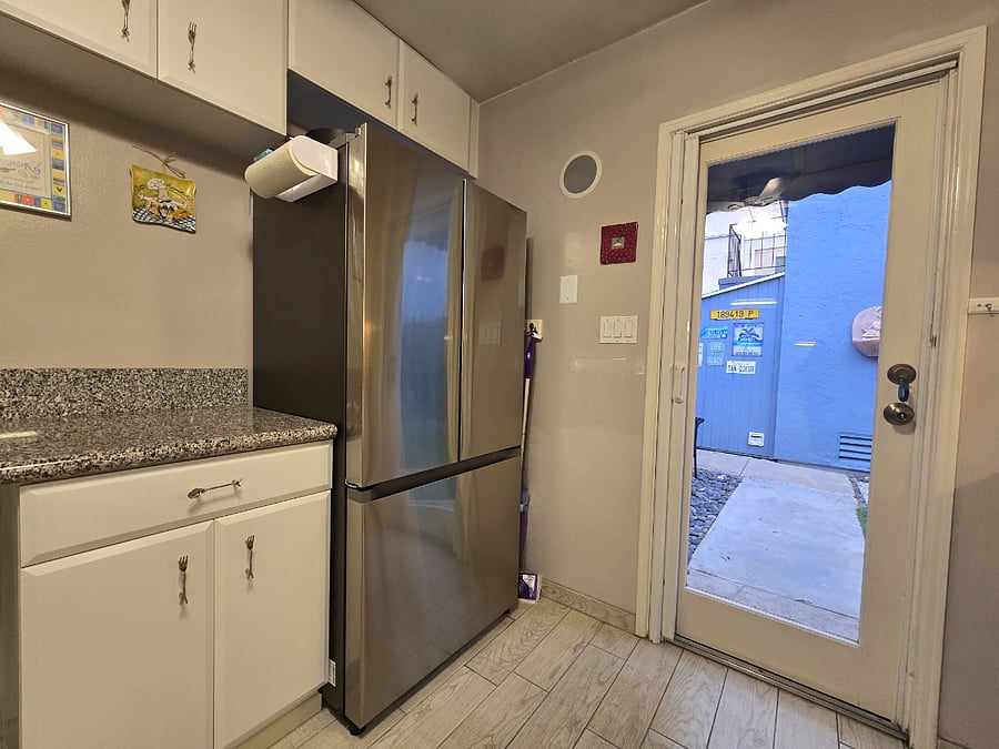 Kitchen with full size SS apliances and granite countertops. Glass door to the private back yard.