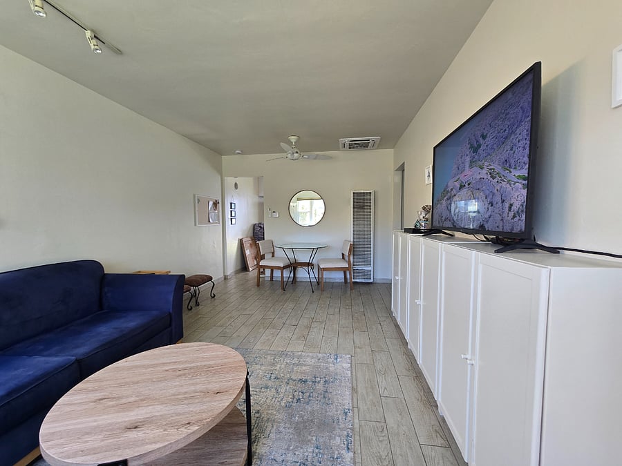 Living room with two blue sofas, 50 inch TV, wall cabinet.