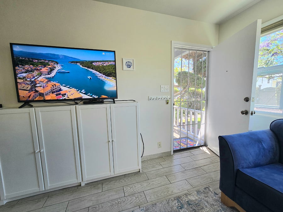 Living room with metal locking screen door.