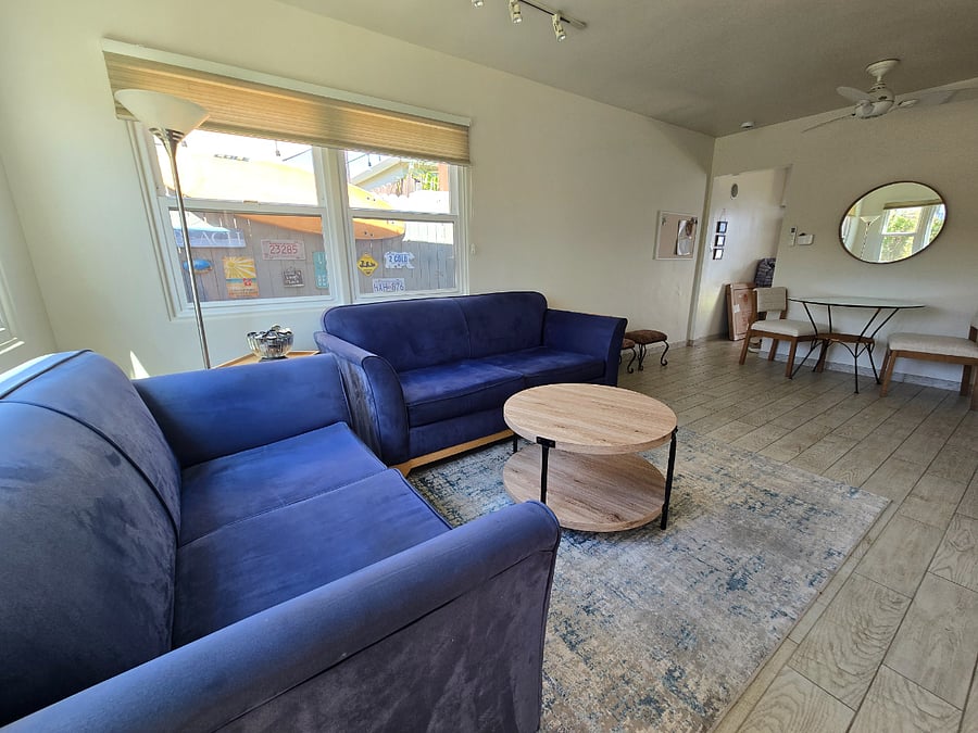 Living room with two blue sofas, 50 inch TV, wall cabinet.