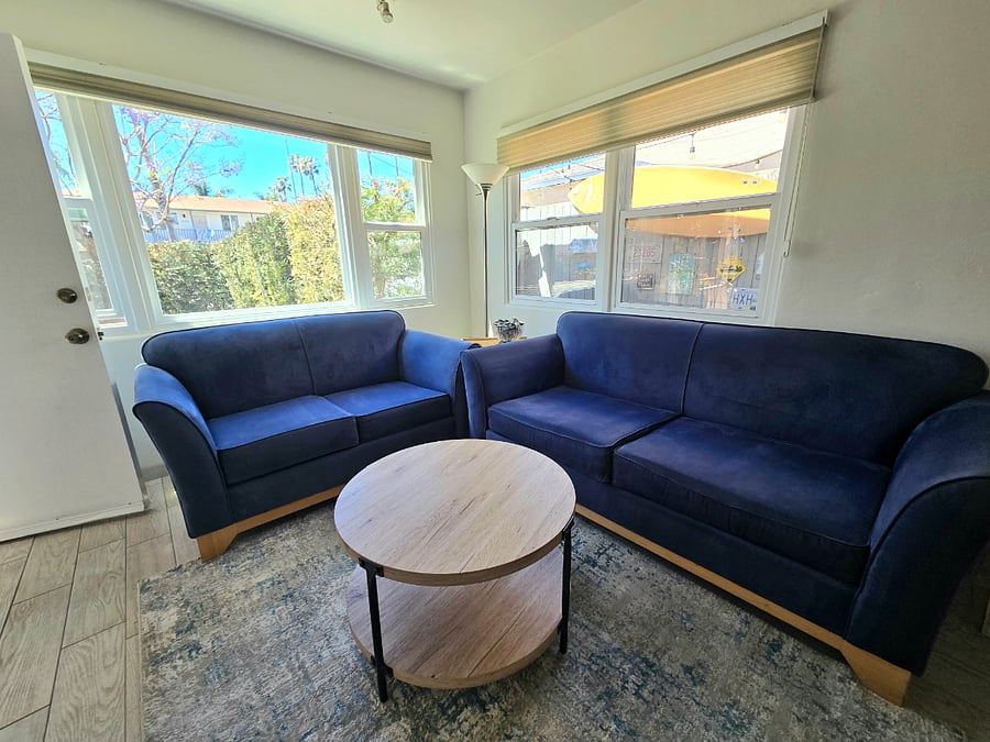 Living room with two blue sofas, 50 inch TV, wall cabinet.