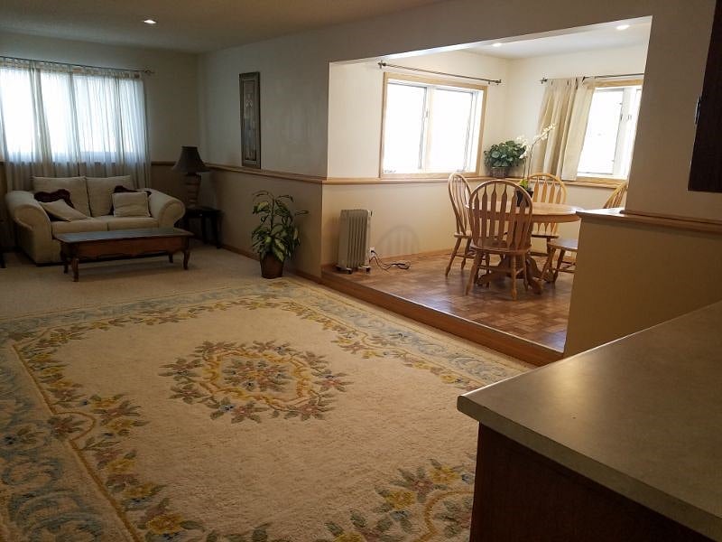 Living room and dining nook from the hallway outside the bathroom