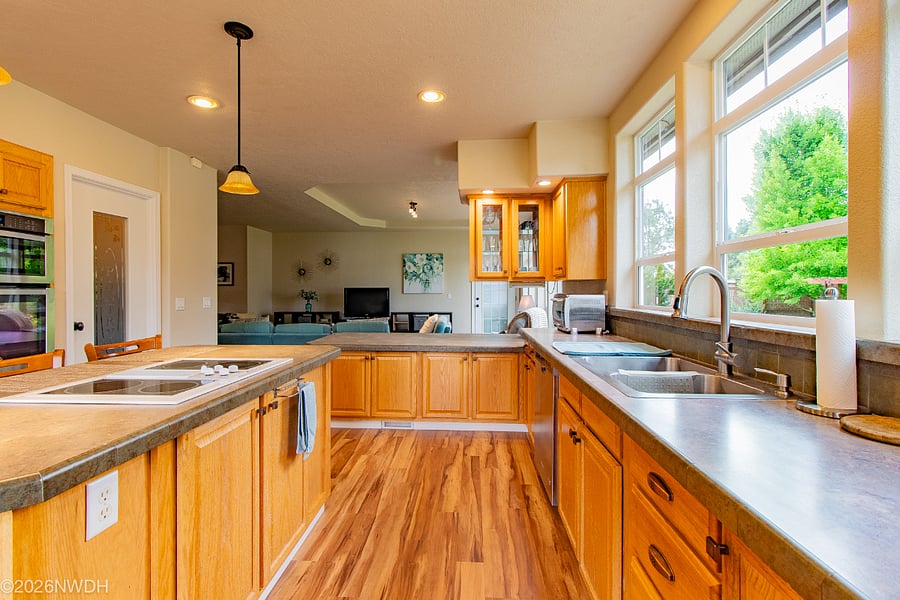 The spacious and fully equipped kitchen leads into the living/family room. It includes a countertop stove, stacked oven and microwave. There is also a large pantry to the right of the oven/microwave.