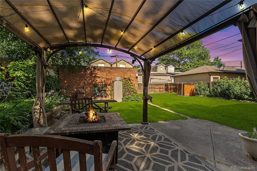 Backyard with pergola, firepit and picnic table. Garden area is near the fence