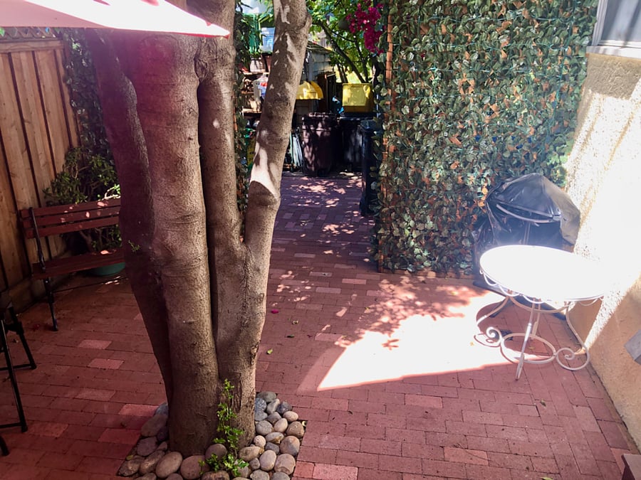 Looking out from your door, you see your electric grill, and at nights fair lights illuminate the ivy on your redwood divider. It's fun!