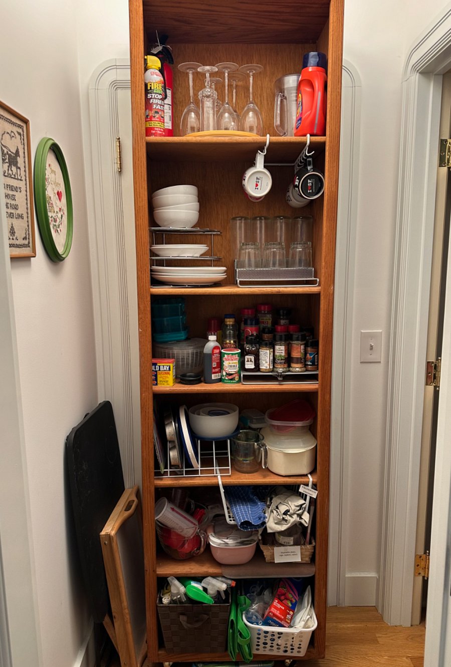 The shelves in the vestibule hold dishes, spices, wine glasses, food storage containers, and other tools for everyday living.