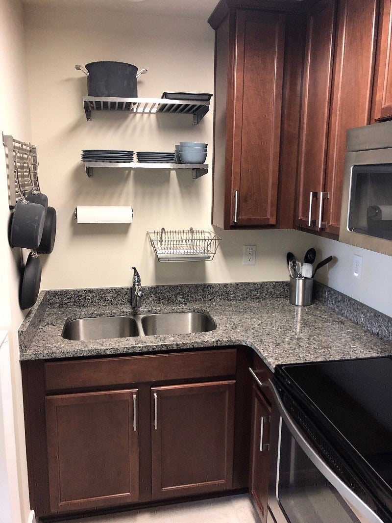 Granite countertops, double sink, disposal, dishes, pots, and pans