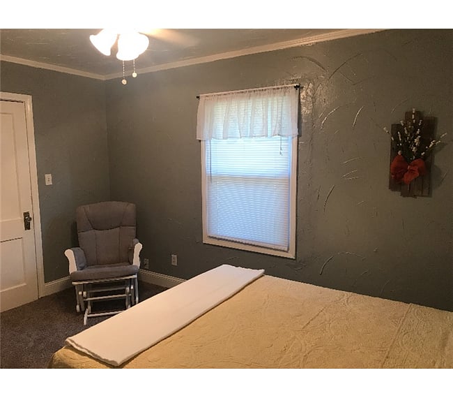 Laundry room is located right of this bedroom.