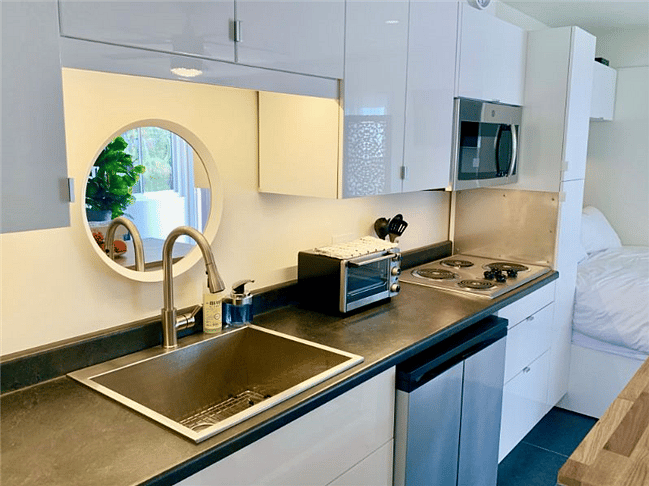 Deep stainless sink, countertop oven, stove-top, apartment freezer/fridge side-by-sides, and a full size microwave.