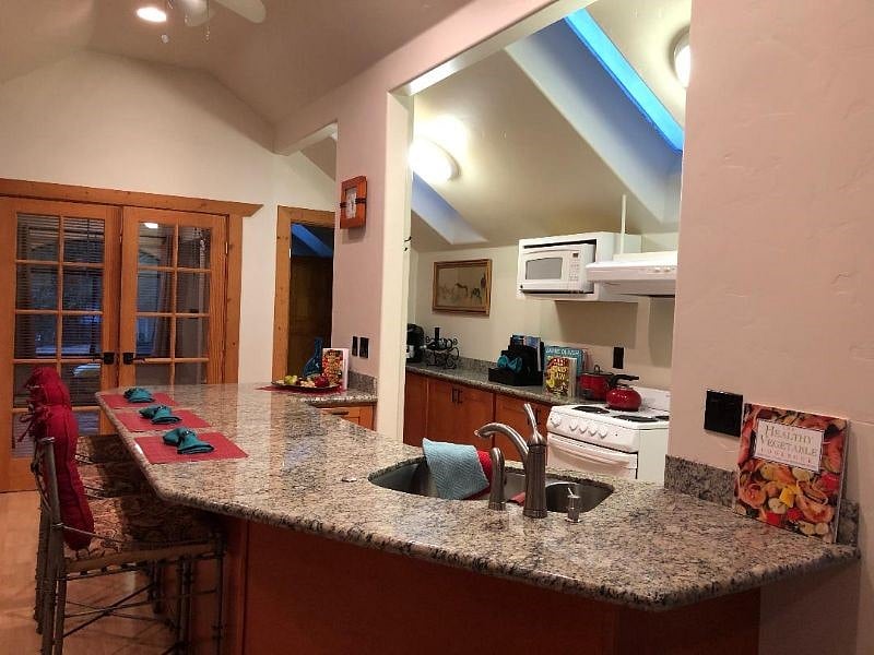 Spacious  Kitchen  Features a Huge granite counter for meal prep and dining Complete with comfortable Chairs . Well stocked for the Chef