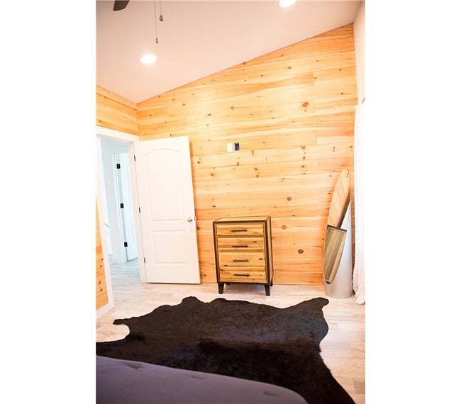 Pine shiplap accents two of the walls in this room. Cowhide rug completes the tile floor.