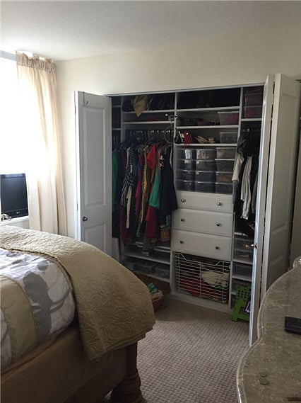 Bedroom w/ closet organizer and bed, dresser, and nightstand
