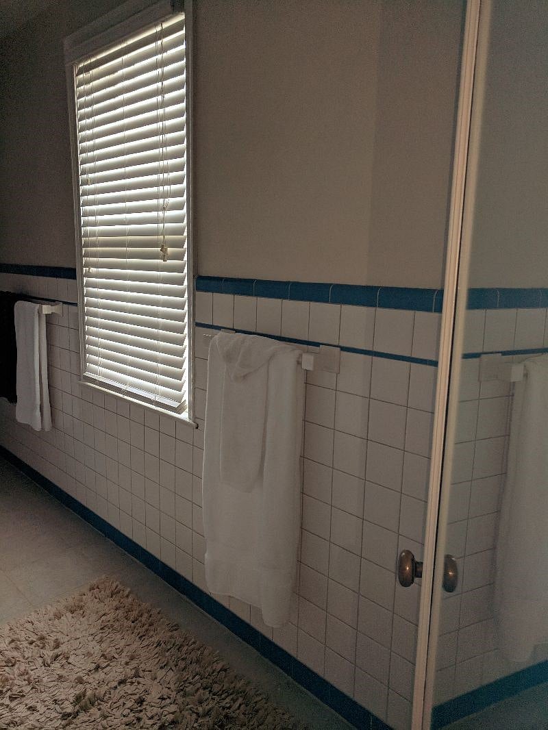 A private bathroom with shower and plenty of storage in linen cabinets