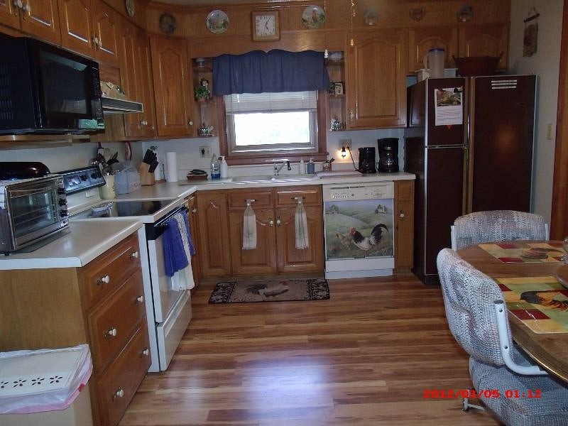 Large Eat-in-kit with Electric Stove, Dishwasher, New Refrigerator. Microwave! Ceiling Fan in Kitchen,Table & chairs, opening to Family Room..