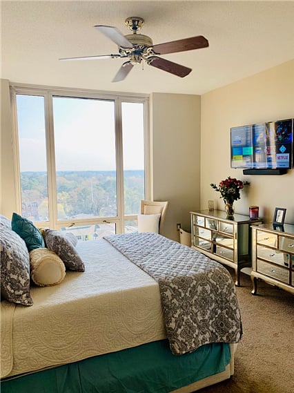 Generously sized bedroom featuring a television, two dressers, and a nightstand.