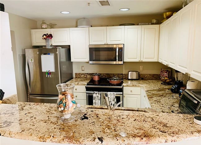 Fully-stocked kitchen with a full sized fridge, stove, and dishwasher.
