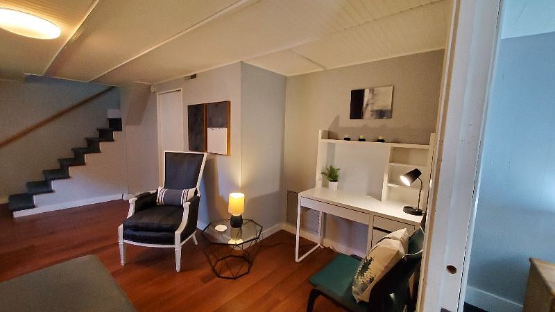 This view shows the desk nook, the door to the bathroom of the suite and the shared laundry area, also the stairs up outside door and shared spaces on the main floor.