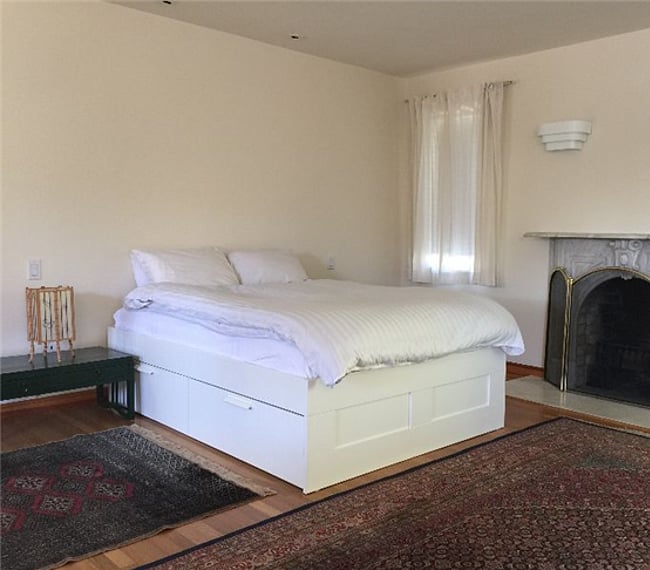 Another view of the Main Bedroom with Decorative Fireplace and two side tables with shoji-style lights