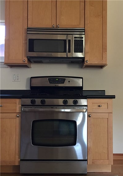 Close up of natural gas 4-burner stove and 1000-watt microwave and extractor hood