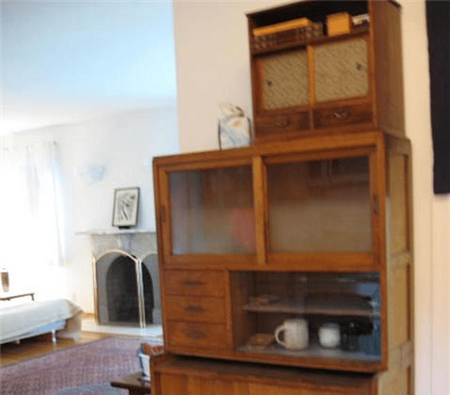 Tea Cabinet opposite the galley kitchen holding small appliances, tea cups, coffee maker