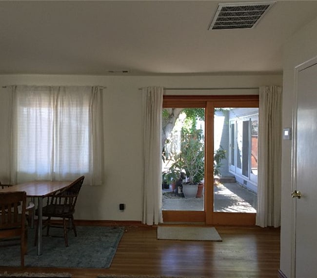 Emergency exit on east side of studio in the form of a sliding door. Owner's residence is seen beyond glass on right. Slider has a screen for creating cross breeze in the summer months
