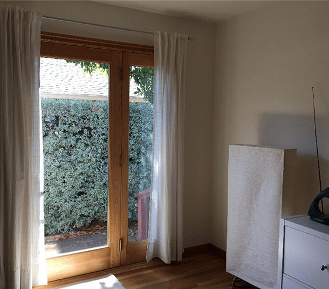 The private entrance to the studio located on the west side of the house with curtains for privacy. Has a locking Marvin door with a glass center so extra light flows into the studio.