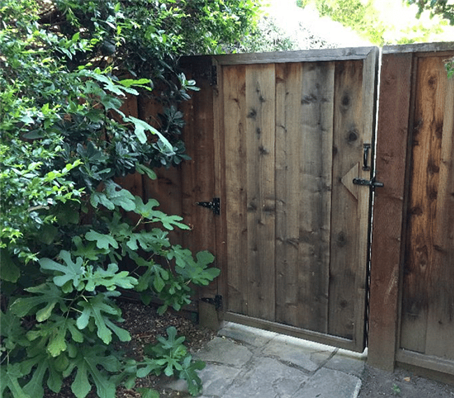 The gate to the west side of the house and the private entrance to the studio. A stone pathway leads from the entrance to the property to the gate and then to the studio entrance