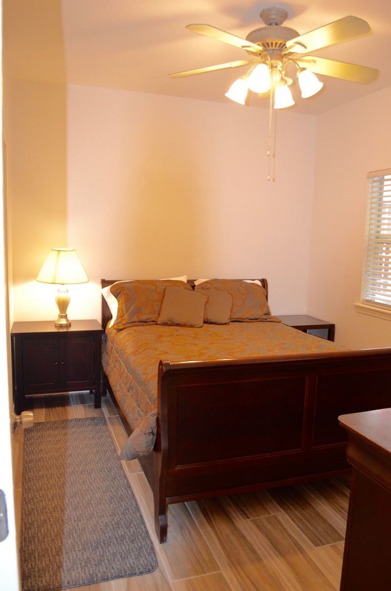 Queen bed with ceiling fan.