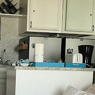 Kitchen island contains pots, pans, blender, toaster, etc.