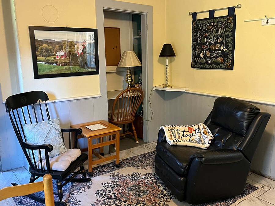 This photo gives you a better view of the sitting area and desk. The cottage was built in 1888 and retains the architectural elements of wainscoting and, in the bedroom, the tongue-and-groove walls. All utilities, amenities, and appliances are updated, and kept updated.