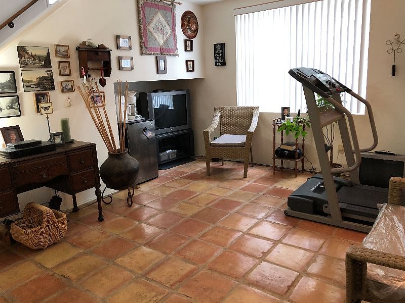 Interior Cozy Condo lower floor sitting area - treadmill - tv- fridge - desk