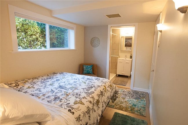 Queen bed with electronics charging station and reading lights in built-in headboard.