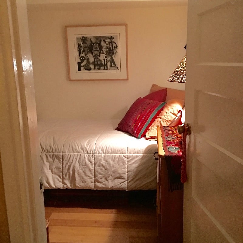 The small room ("monk room)" with a single bed, small bedside chest with 3 drawers, wall bookcase with lots of books, no closet