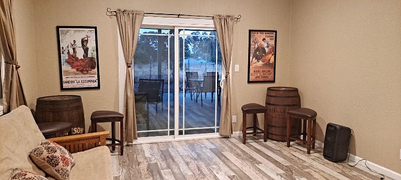 2nd bedroom has whiskey barrels with stools and slider to backyard
