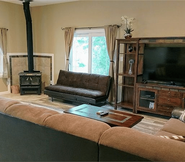 Another view of living room with  old fashioned wood burning stove for cozy fire. Home also has central heat & A/C