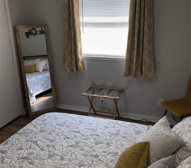 Bedroom complete with closet, luggage stand, and full size mirror.