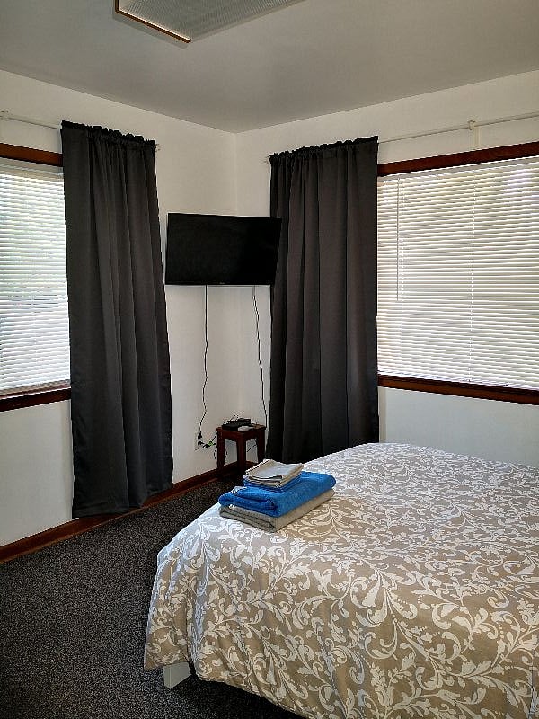 This bedroom has brand new carpeting, This bedroom has the most windows of any bedroom in the house. The Venetian blinds are for privacy and for day-time views & sunshine while the full set of black-out curtains is for when daytime sleeping is important!. The wall-mounted Smart TV & WiFi will offer some relief after a long day at the hospital.. Just prop up the pillows, turn on a movie and enter the Zone!