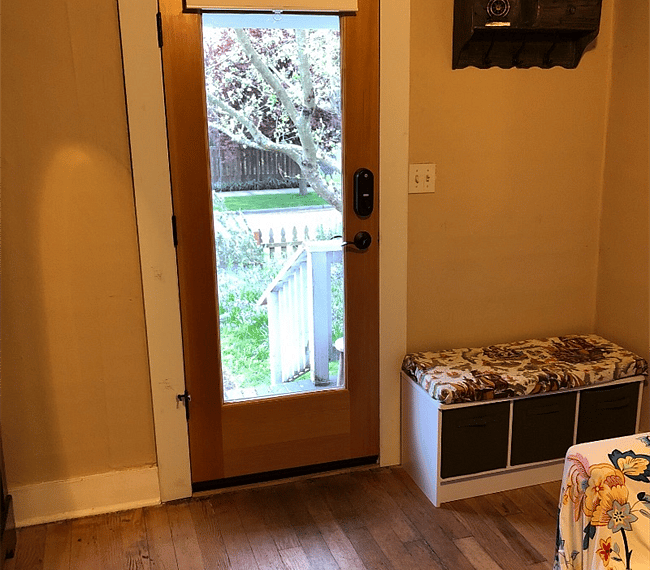 View out front door from living room. Storage bins under entryway bench and a place to hang your hats and hoodies.