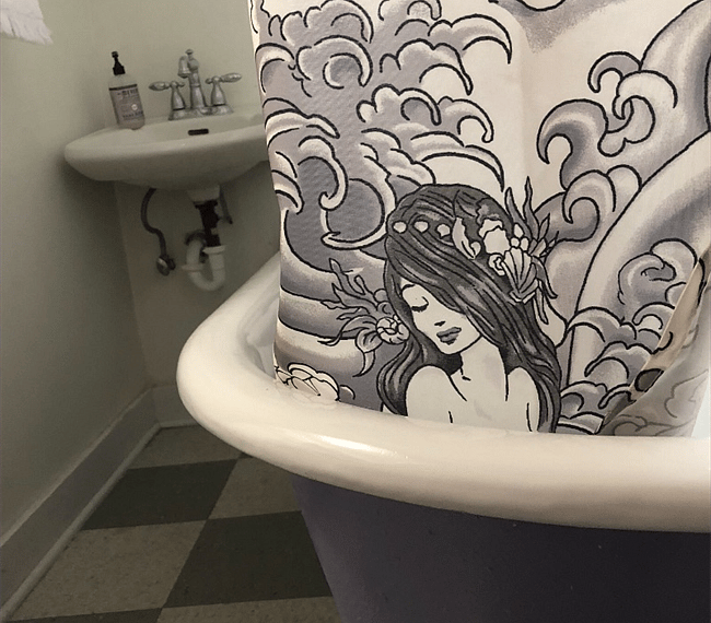 Full size claw foot tub and mermaid tattoo shower curtain.