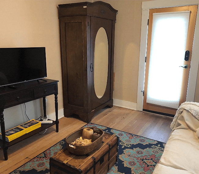 Living room with TV and armoire with lots of hangers to hang your clothes.