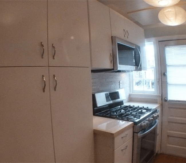 The kitchen features lovely bright cabinets, beautiful custom lighting, a large refrigerator, full stove/oven, microwave and dishwasher