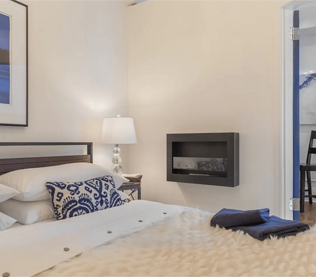 Fireplace in bedroom; high end bedding and decor
