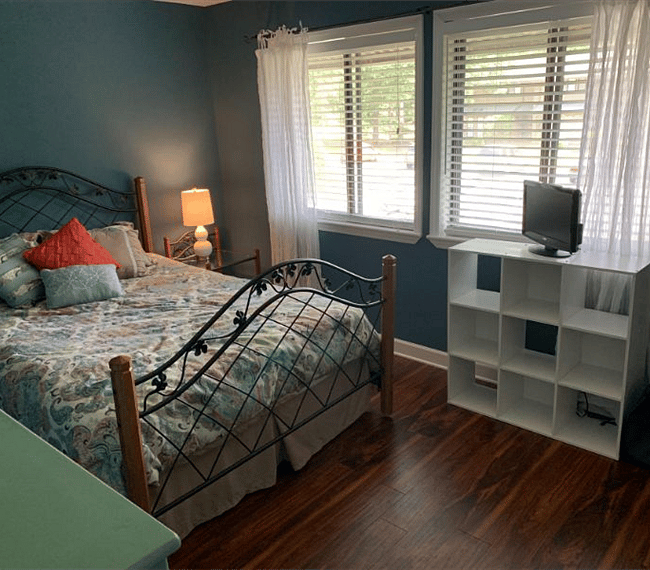 Private bedroom with queen bed, TV & two large windows with blinds