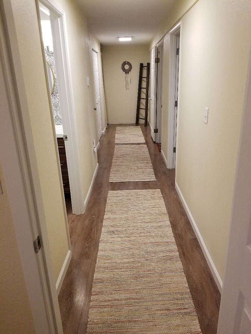 Downstairs Hallway Looking from Downstairs 3rd Bedroom with Private bath to the left, and Laundry room and Stairwell up to main-level at the end of hall.