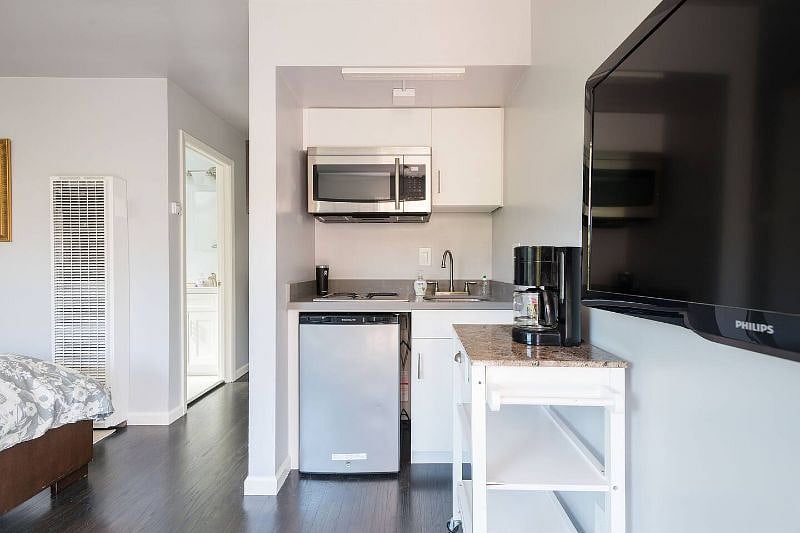 Well stocked kitchen area with microwave, stove top and refrigerator.