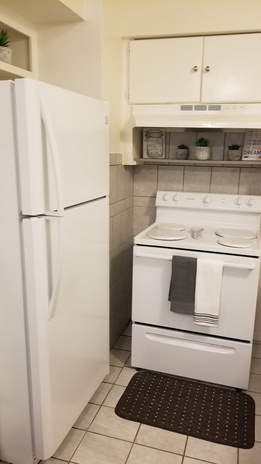 Refrigerator with top freezer, lower vegetable trays, two metal shelves, butter compartment and door storage for beverages